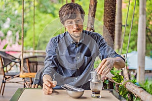 Caucasian man and traditional drip brewed Vietnamese coffee from a phin filter