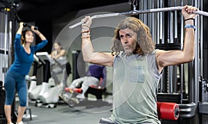 Caucasian man training on lat pull down machine in gym