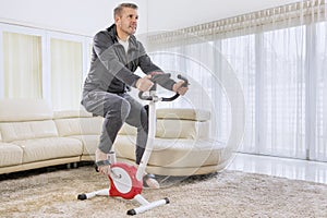 Caucasian man training with a spin bike at home