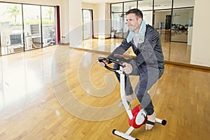 Caucasian man training with a spin bike at indoors