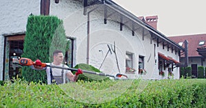 Caucasian man using electric trimmer for shaping bushes