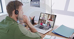 Caucasian man using laptop and phone headset on video call with colleagues