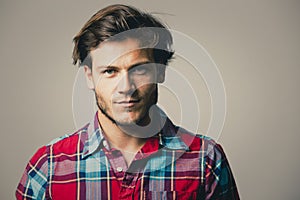 Caucasian man wearing checkered shirt and trendy hairstyle