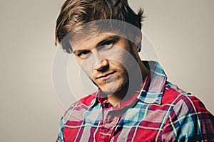 Caucasian man wearing checkered shirt and trendy hairstyle