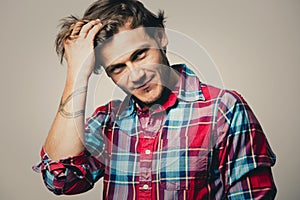 Caucasian man wearing checkered shirt and trendy hairstyle