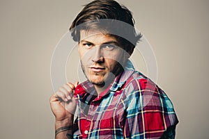 Caucasian man wearing checkered shirt and trendy hairstyle