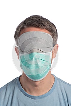 Caucasian man wearing a protection mask and a sleeping mask on a white background