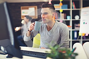 Caucasian man at work desk facing flat screen computer