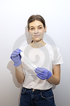 Caucasian manicurist, nail technician holds file in hands, wearing gloves. White smiling photo