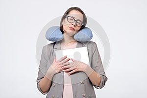 Caucasian matur woman in glasses resting with travel pillow in vacation trip