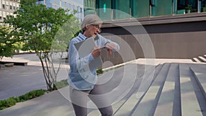 Caucasian mature 50s old woman businesswoman business employer walking up stairs going upward office building in city