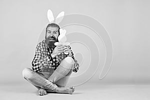 Caucasian mature hipster in buny ears with trendy hairstyle in checkered shirt celebrate easter, copy space, easter joy