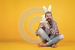 Caucasian mature hipster in buny ears with trendy hairstyle in checkered shirt celebrate easter, copy space, easter joy