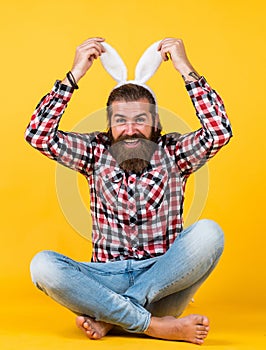 Caucasian mature hipster in buny ears with trendy hairstyle in checkered shirt celebrate easter, easter fun