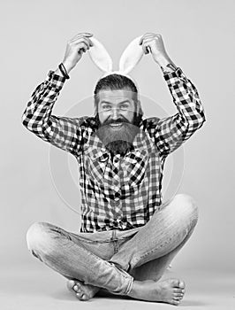 Caucasian mature hipster in buny ears with trendy hairstyle in checkered shirt celebrate easter, easter fun