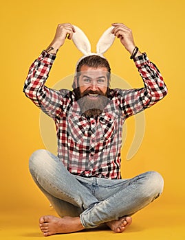 Caucasian mature hipster in buny ears with trendy hairstyle in checkered shirt celebrate easter, easter fun