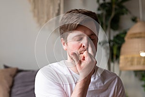 Caucasian mature man practicing yoga sitting, making Alternate Nostril Breathing