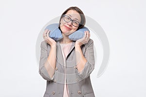 Caucasian mature woman smiling holding travel pillow on neck travelling in comfort.