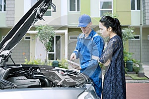 Caucasian mechanic talking with his client