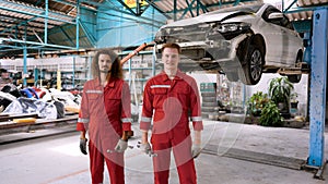 Caucasian mechanic who specializes in car repairs Standing in a large mechanic\'s red suit. Standing with a smile