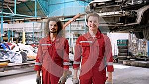 Caucasian mechanic who specializes in car repairs Standing in a large mechanic\'s red suit. Standing with a smile showing