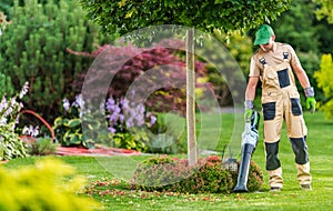 Men with Leaf Blower Cleaning Backyard Garden photo