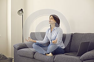 Caucasian middle age self-employed woman entrepreneur meditating on home sofa