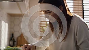 Caucasian middle age woman standing in kitchen and making a soup.