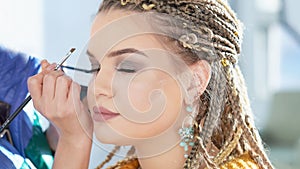 Caucasian model false eyelashes during make-up session.. The model has white, clean complexion.