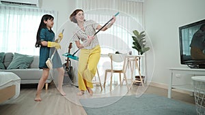 Caucasian mom and child doing housework together and dancing to music. Pedagogy.