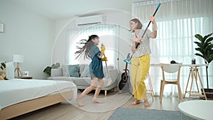 Caucasian mom and child doing housework together and dancing to music. Pedagogy.