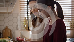 Caucasian mom and daughter cooking soup together.