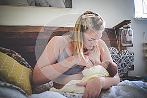 Caucasian mother breastfeeding her newborn baby at home