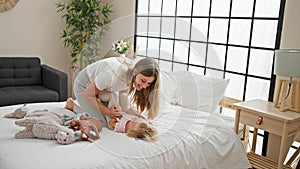 Caucasian mother and daughter tickle-fest! a heartwarming scene of laughter in the bedroom, lying on the bed, sharing a lot of photo