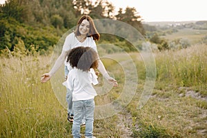 Caucasian mother and her mixed race daughter running on a field