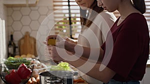 Caucasian mother teaching daughter how cook the soup.