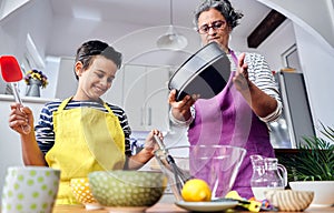 Caucasian mother teaching her son how to cook preparing the ingredients to make a cake