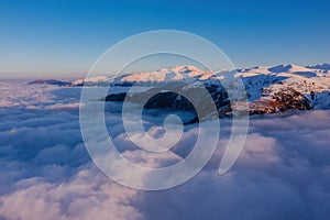 Caucasian mountains above the clouds at the sunset