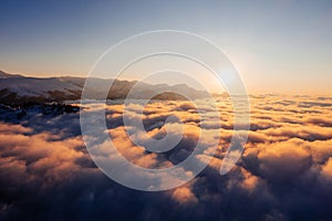 Caucasian mountains above the clouds at the sunset. Cloudscape, aerial view