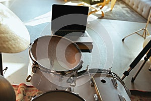 Caucasian musician playing drumms during online concert with the band at home isolated and quarantined, focus on blank