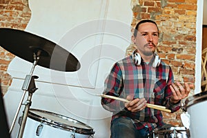 Caucasian musician playing drumms during online concert with the band at home isolated and quarantined, smiling