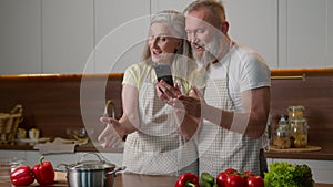 Caucasian old family mature love couple smiling middle-aged man woman use phone order healthy food with mobile delivery