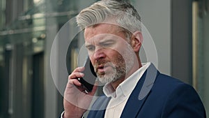 Caucasian old retired business man mature senior businessman leader employer talking mobile phone call smartphone take