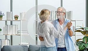 Caucasian old senior elderly happy grandparents lover married couple standing smiling look at each other face listening to slow