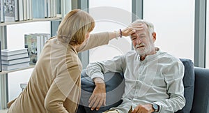 Caucasian old senior elderly supportive wife sitting use hand testing temperature from unhealthy gray bearded and hair husband