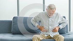 Caucasian old senior elderly unhealthy sick ill male husband grandpa holding hands on stomach having emergency stomachache