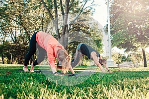 Caucasian people doing yoga in park outside on sunset
