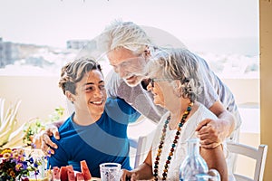 Caucasian people mixed ages and generations - grandfathers and grandson together family at the table eating food and enjoying photo