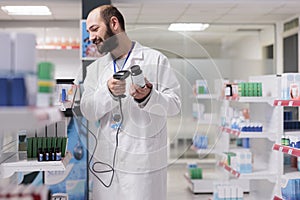 Caucasian pharmacist holding medicament bottle scanning product bar code