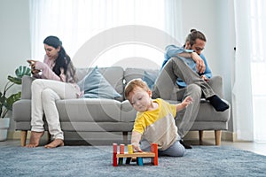 Caucasian phone addict parents don`t pay attention with baby toddler. Family problem, Father and Mother sit on sofa and using